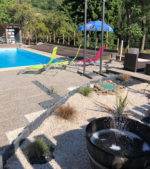 La piscine avec espace détente du Domaine L’Écrin Vert camping nature en Aveyron