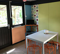 Dining area of the 6-person comfort lodge for rent, at the Écrin Vert nature campsite