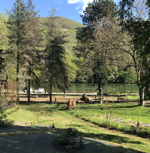 Pitch with a panoramic view of the Tarn river which borders the Écrin Vert nature campsite, in Aveyron